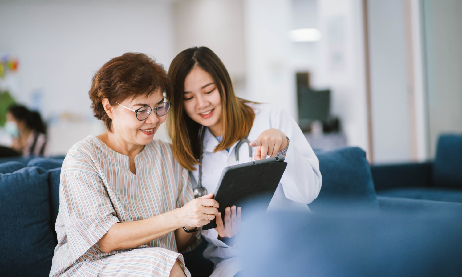 Asian women looking at tablet to provide informed consent